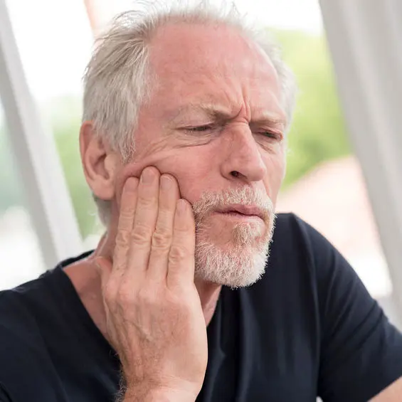 person holding jaw in pain