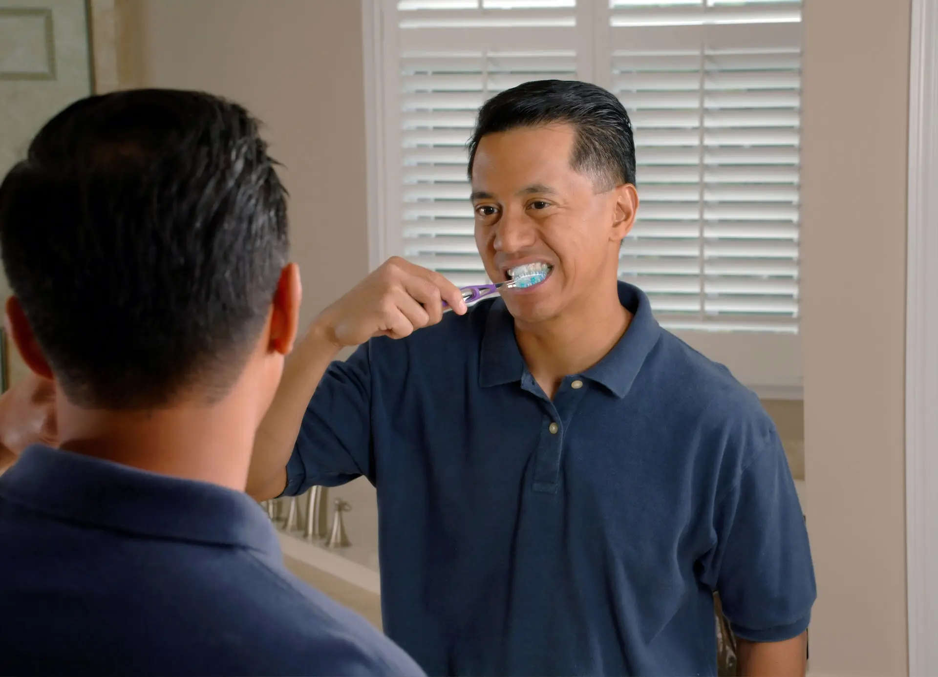 man brushing his mouth - brushing your tongue helps halitosis