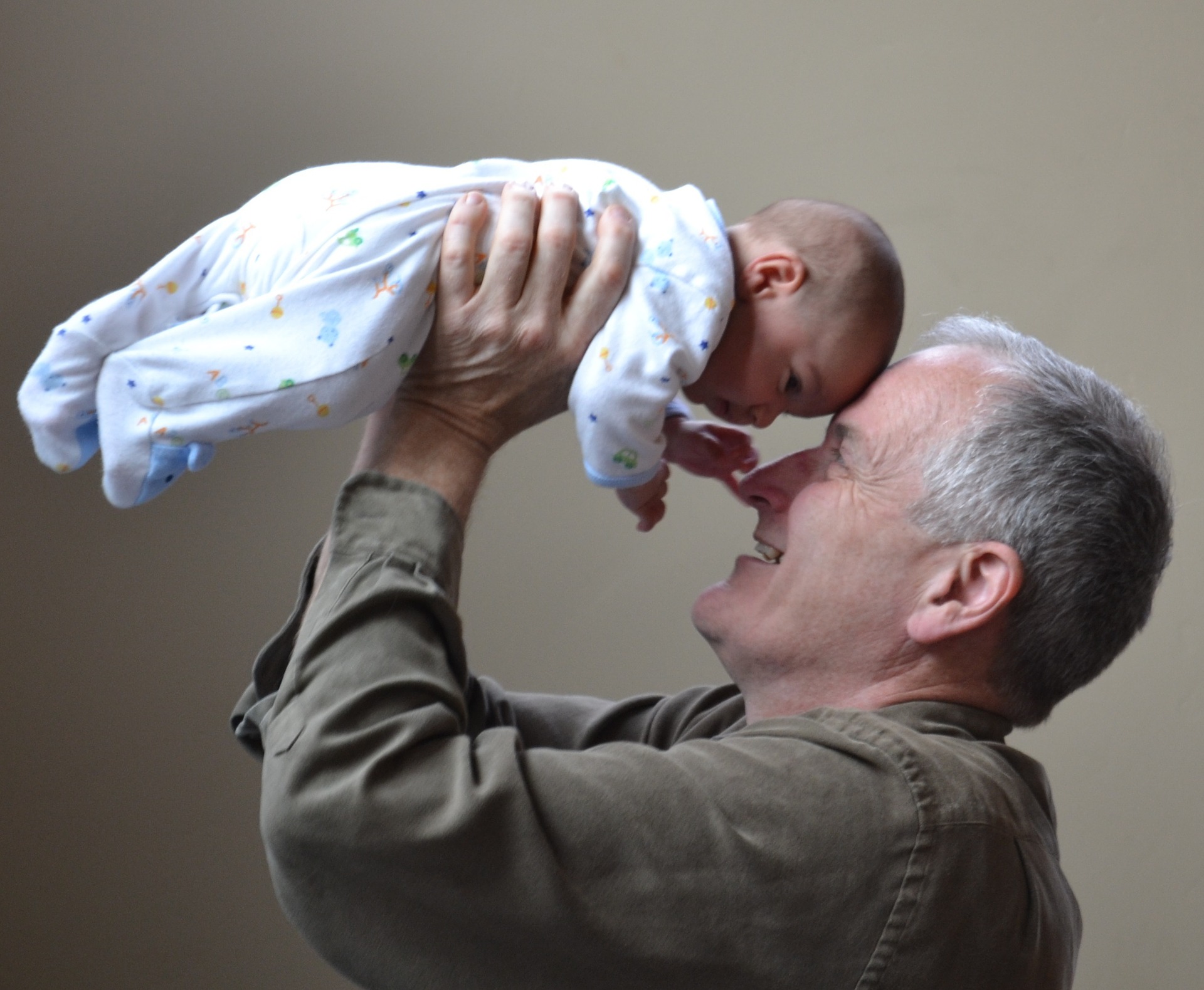 Aging and Dental Health in Prescott - grandfather holding up baby