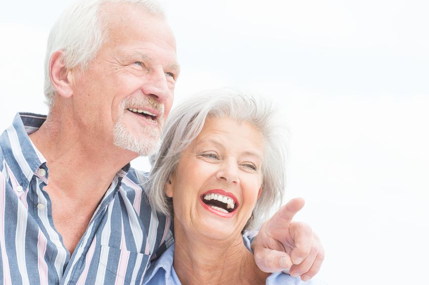 portrait from a happy senior couple in front of cloudy sky