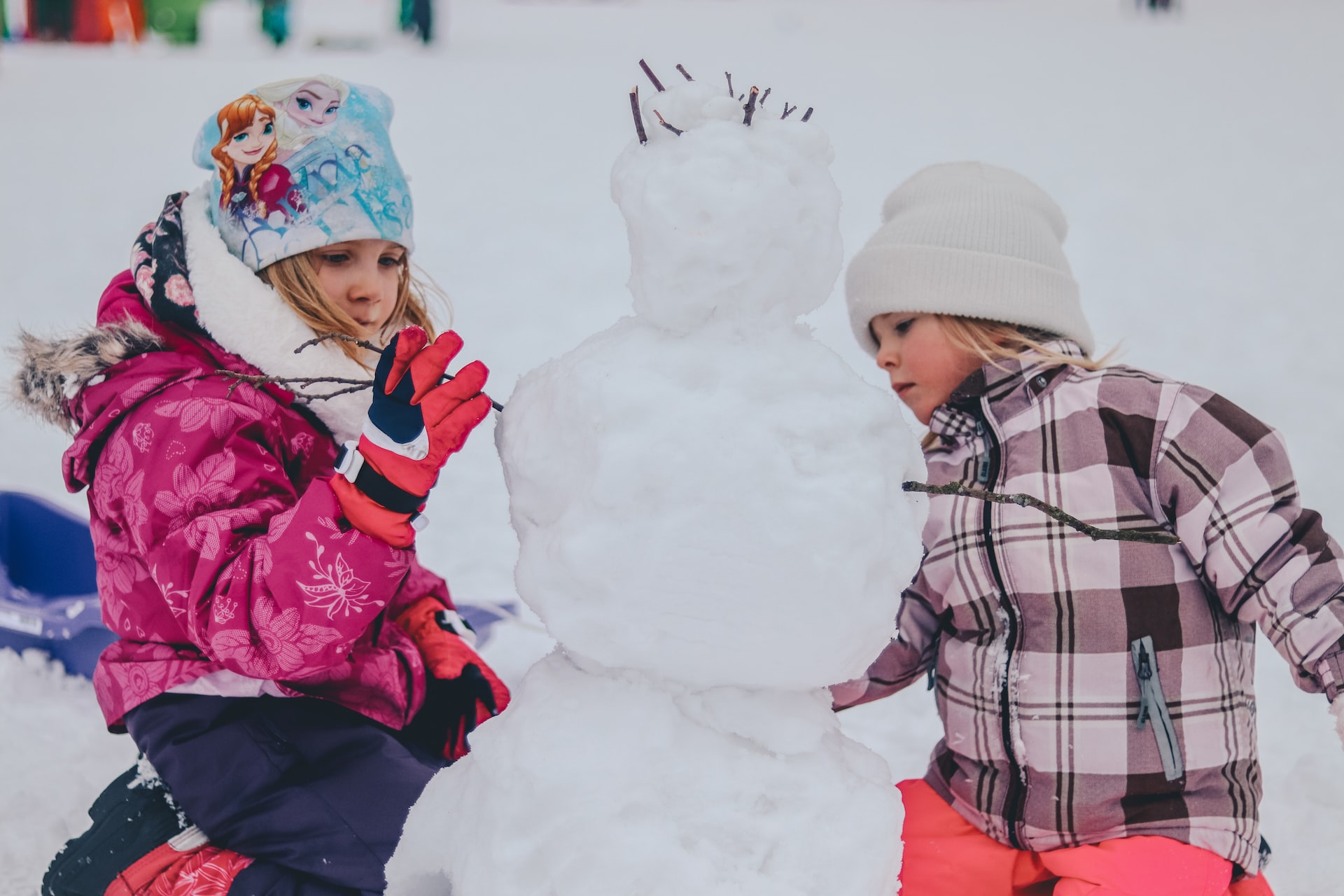 coat drive 2022 - two kids building a snowman
