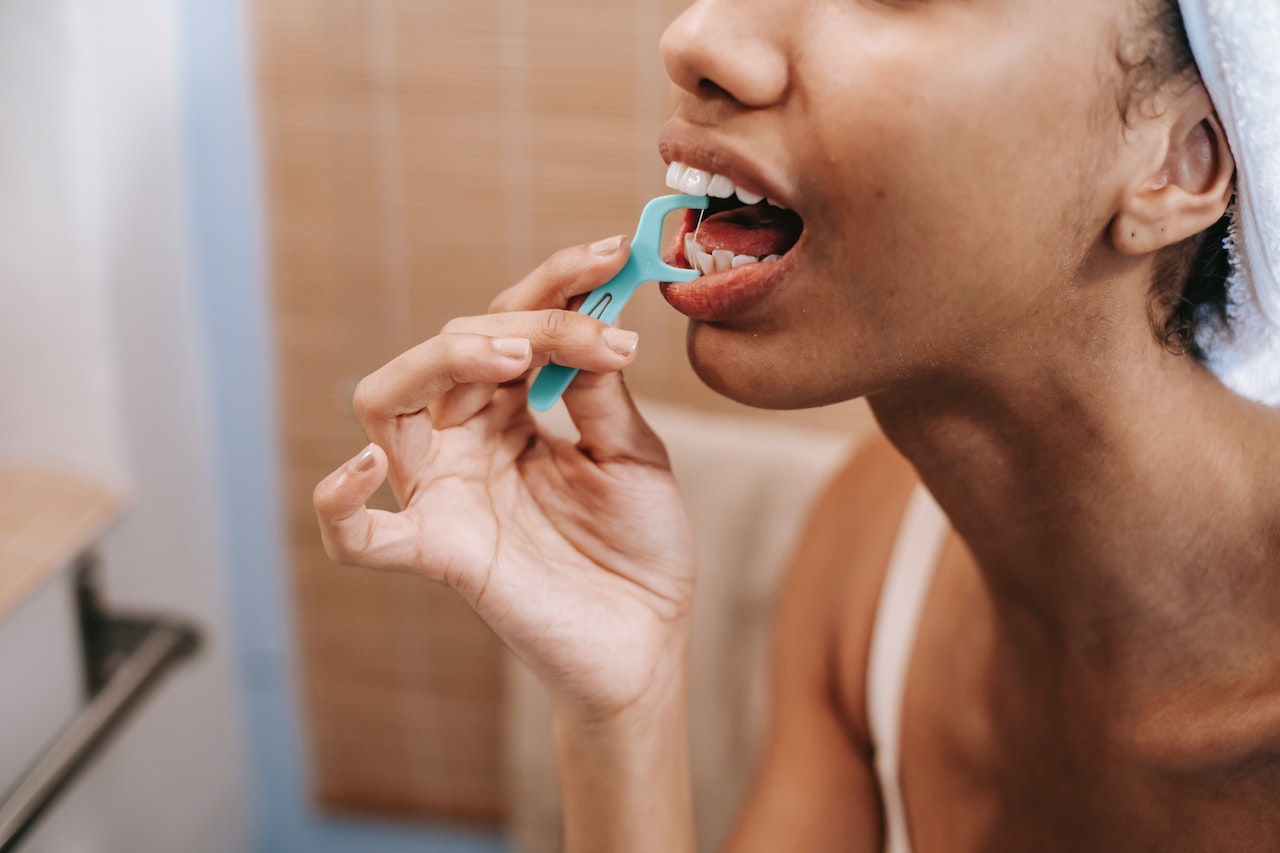 woman who is flossing with a pick - best time to floss