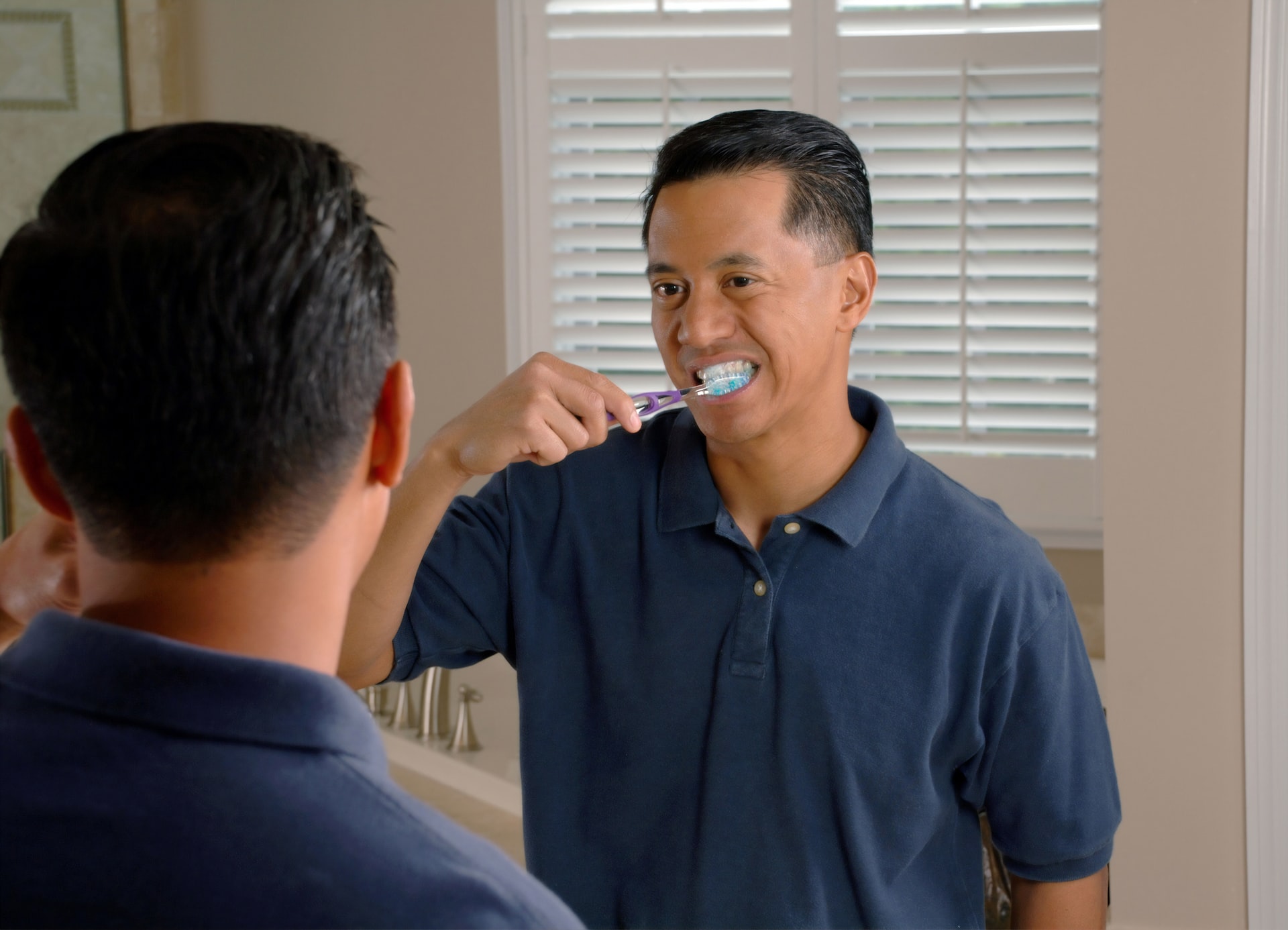 man brushing his mouth - brushing your tongue helps halitosis