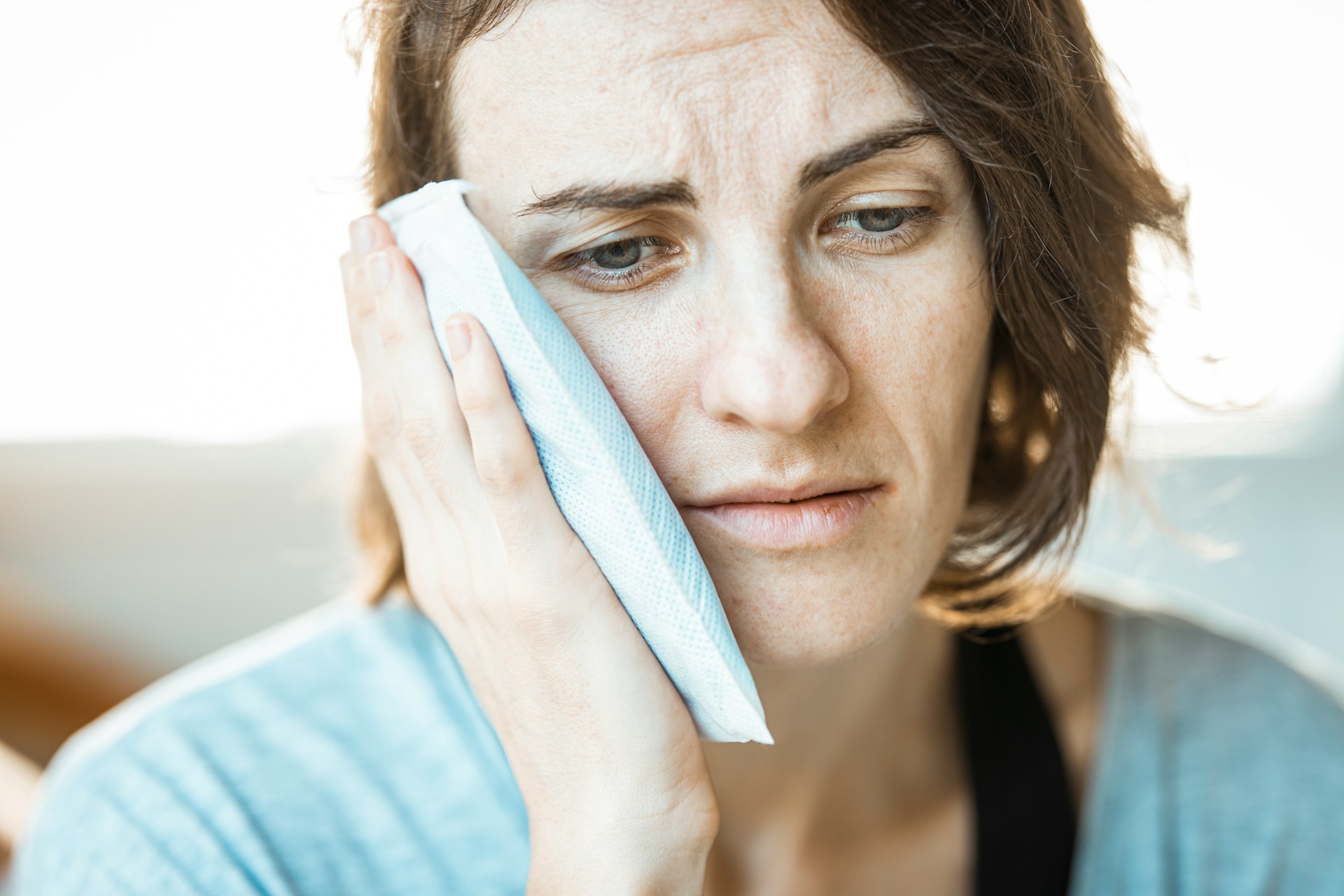woman with icepack and looking sad - what is dentin