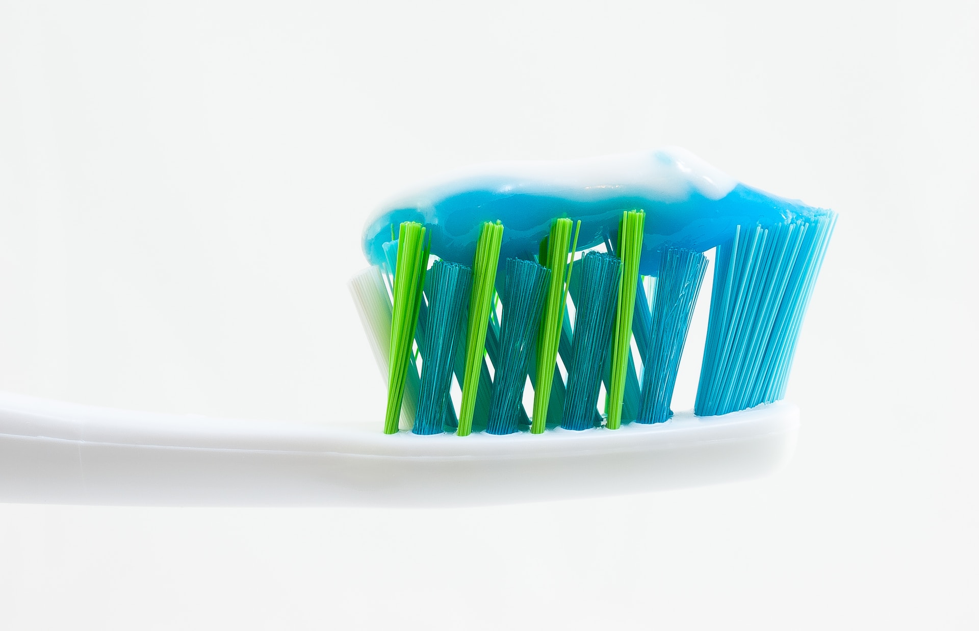 tooth brush with toothpaste on its bristles - types of toothpaste